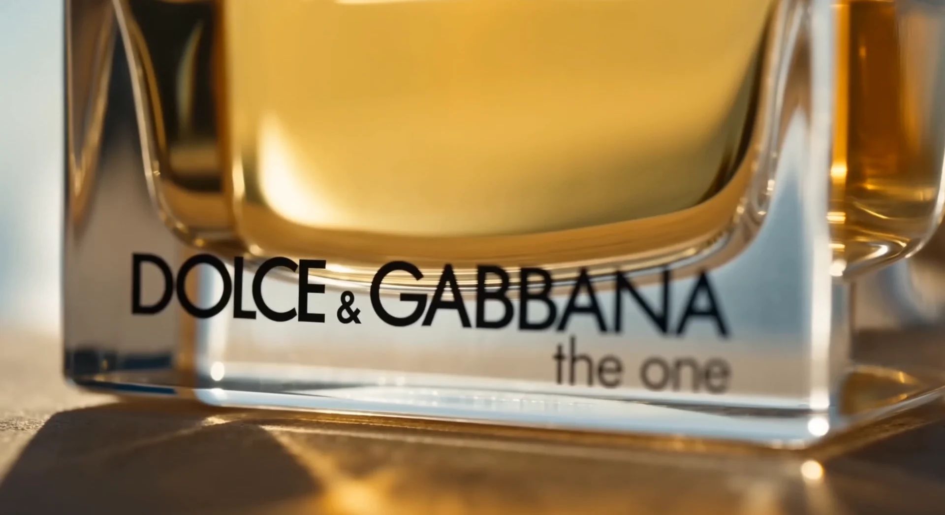 Macro detail of The One fragrance bottle in golden light